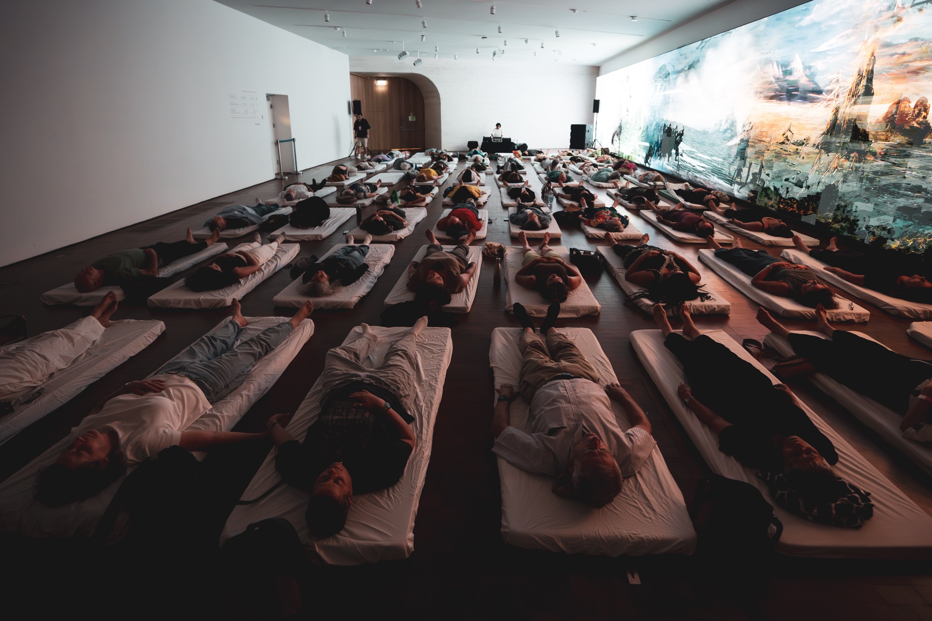 מבט רחב על אולם המוזיאון מלא במשתתפים שוכבים